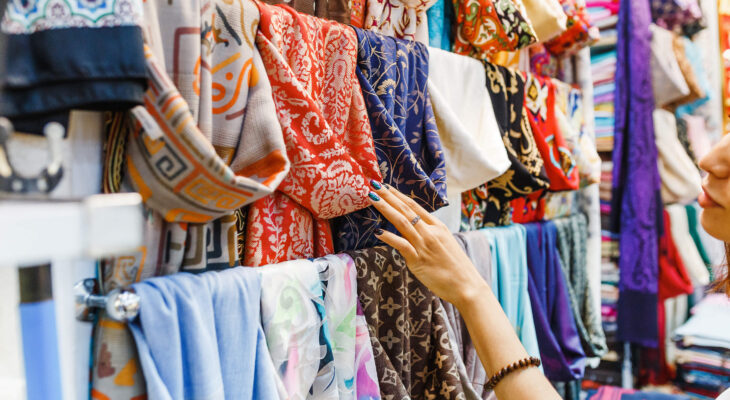 young woman shopping for a new colorful scarf at a mobile boutique