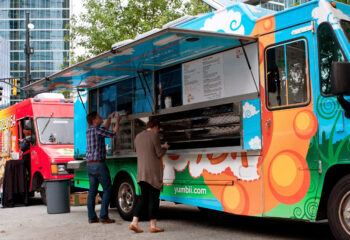 two colorful food trucks in a city center