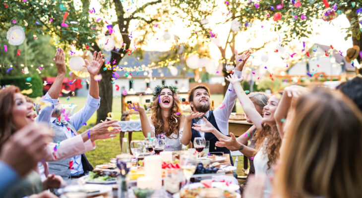 bride and groom in a wedding reception together with the wedding guests eating food from a food truck