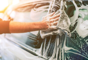 mobile car wash owner washing a customer's car