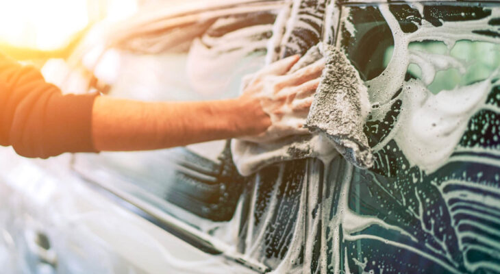 mobile car wash owner washing a customer's car