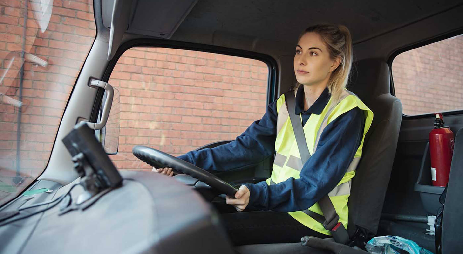 young female worker in a semi truck driving to work