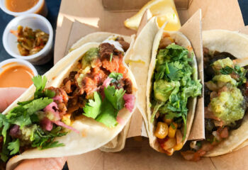 person holding halal corn tacos being sold in a halal food truck