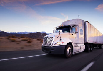 white trailer truck in a highway at dusk