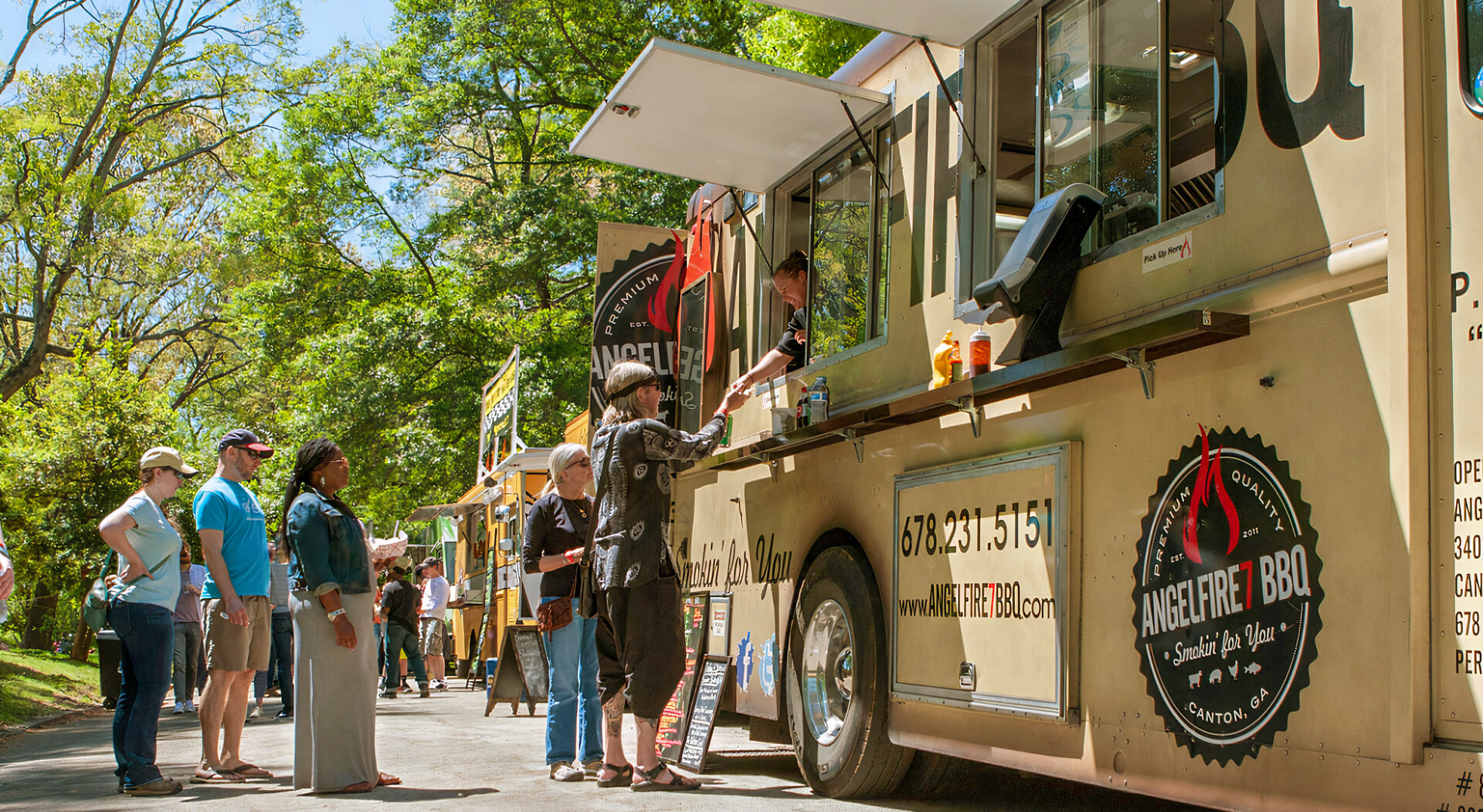 people standing in line to buy meals from a food truck lined up in a food truck festival