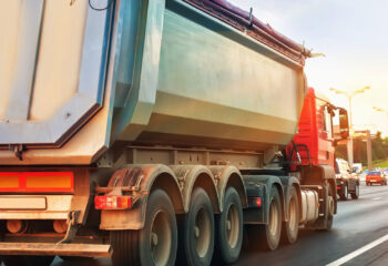 dump truck goes at dusk on highway