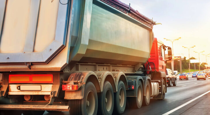 dump truck goes at dusk on highway