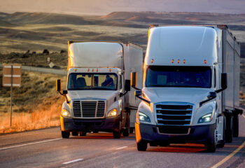 long haul semi-truck rolling down a four-lane highway at dusk