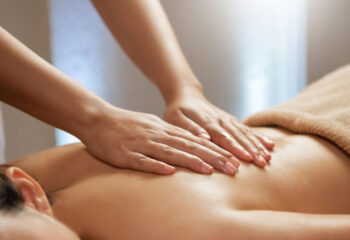 masseuse doing massage on a female body in the spa salon