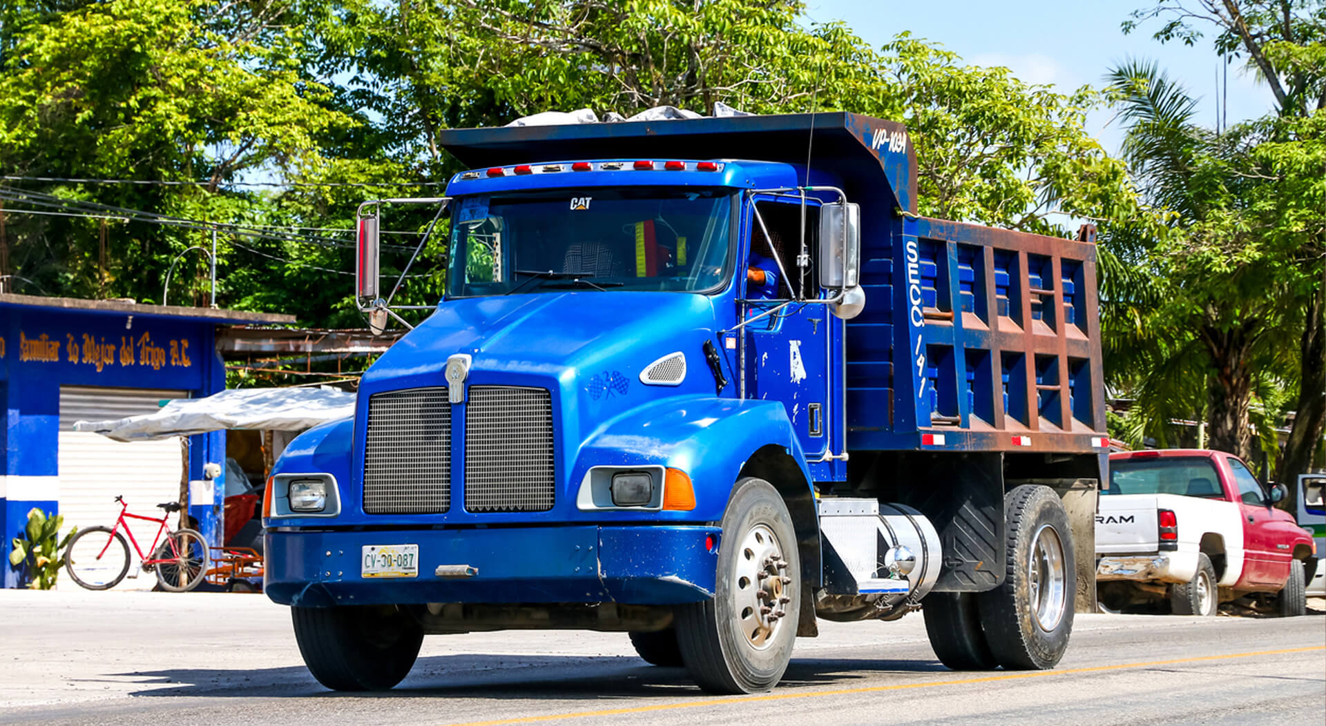 blue Kenworth T300 dump truck in the town street