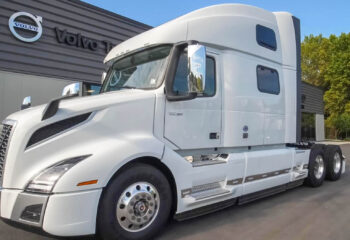 new white Volvo sleeper cab near the car dealership