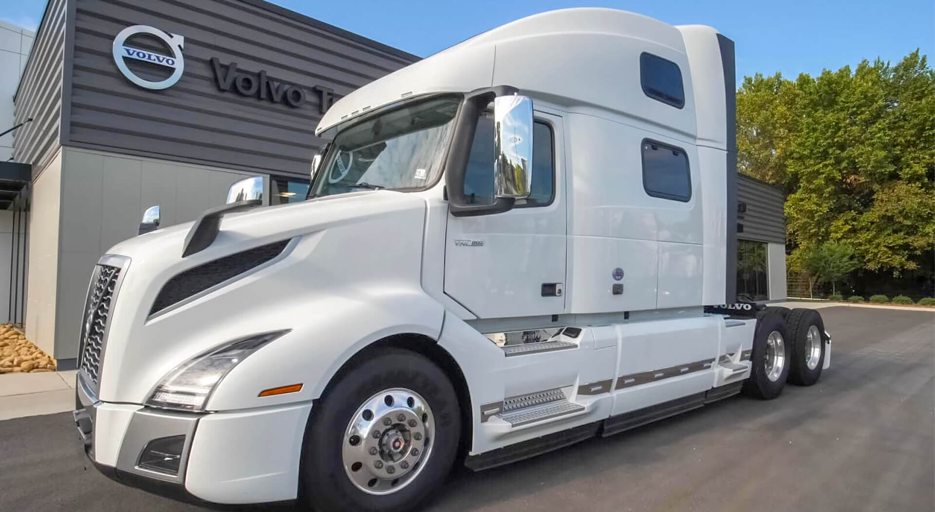 new white Volvo sleeper cab near the car dealership