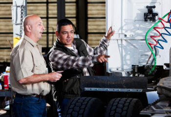 semi truck mechanics in a service garage with semi truck