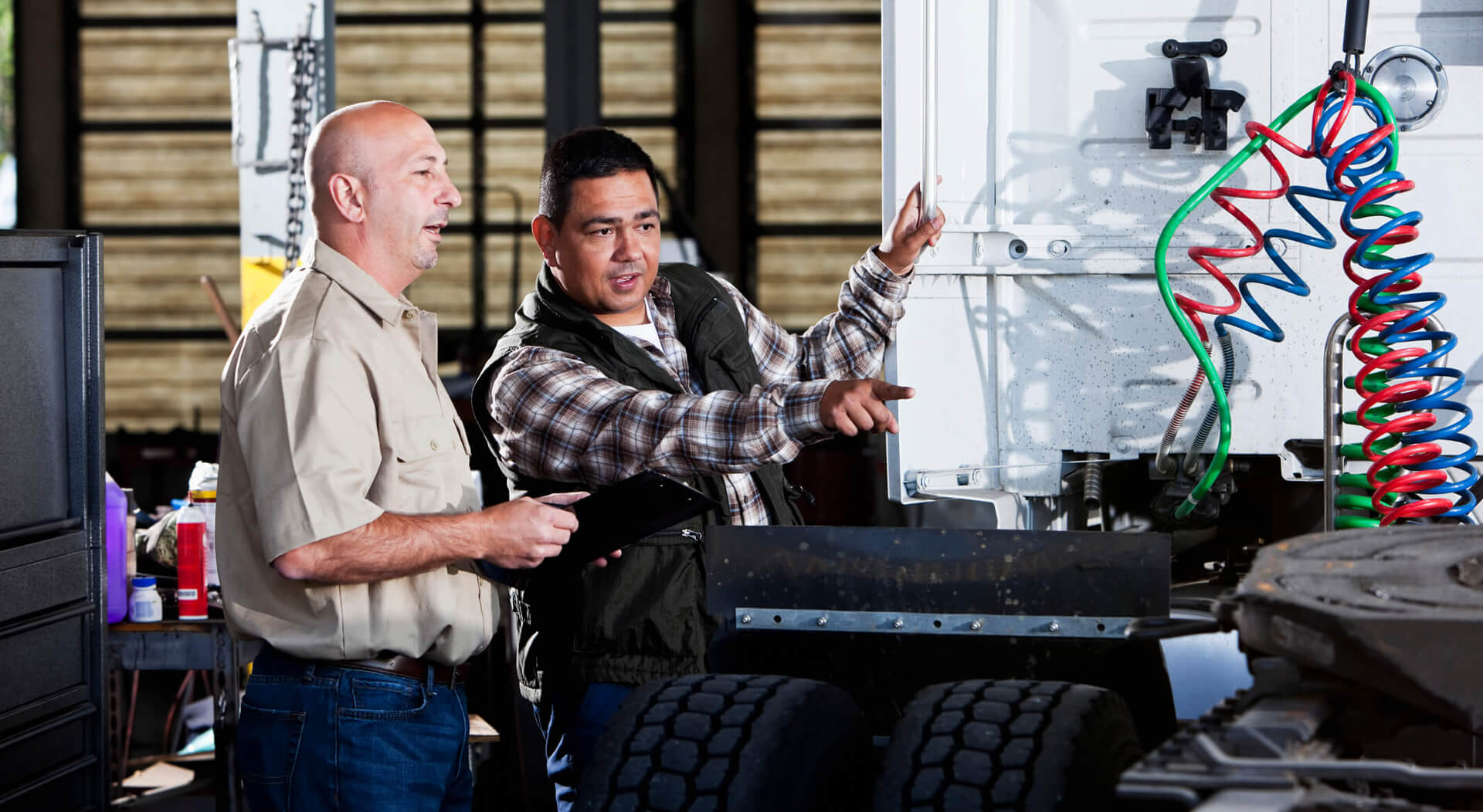 semi truck mechanics in a service garage with semi truck