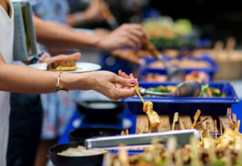 woman taking food from a food tray