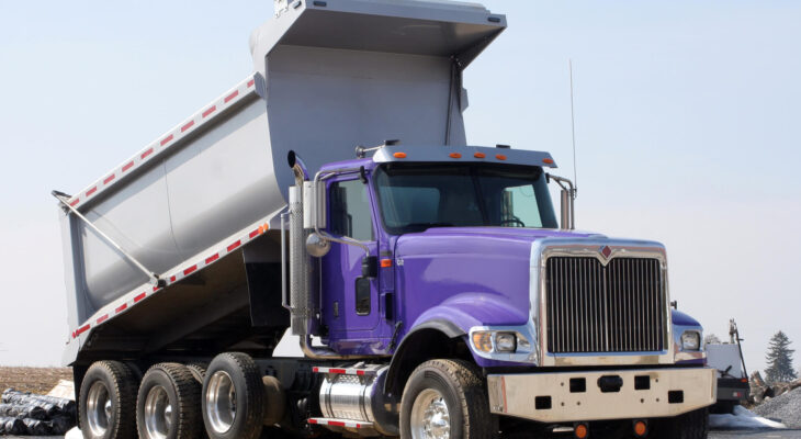 purple dump truck at a construction site
