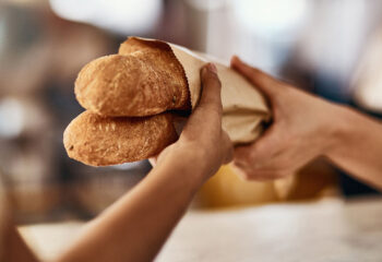 woman buying freshly made baguettes at a bakery food truck