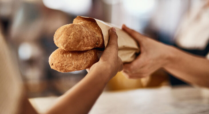 woman buying freshly made baguettes at a bakery food truck