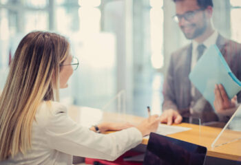 young businessman at the bank counter, talking to his advisor about financing options for his mobile business