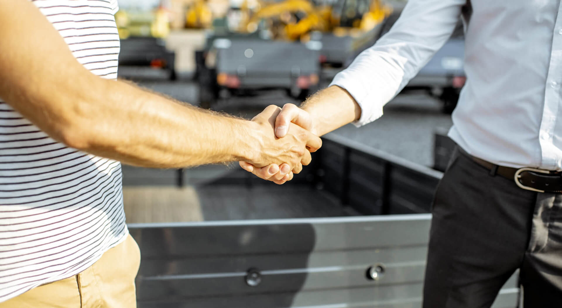 two businessmen shaking hands after sale of used semi truck