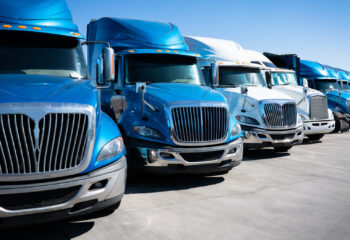 fleet of blue 18 wheeler semi trucks