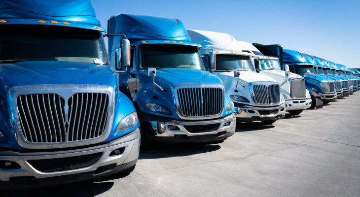 fleet of blue 18 wheeler semi trucks