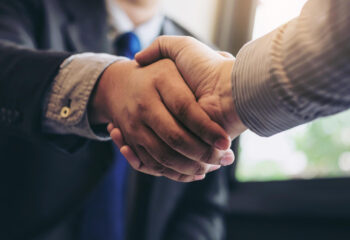 business men shaking hands during a meeting to sell truck