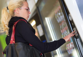 casual caucasian woman using a modern beverage vending machine