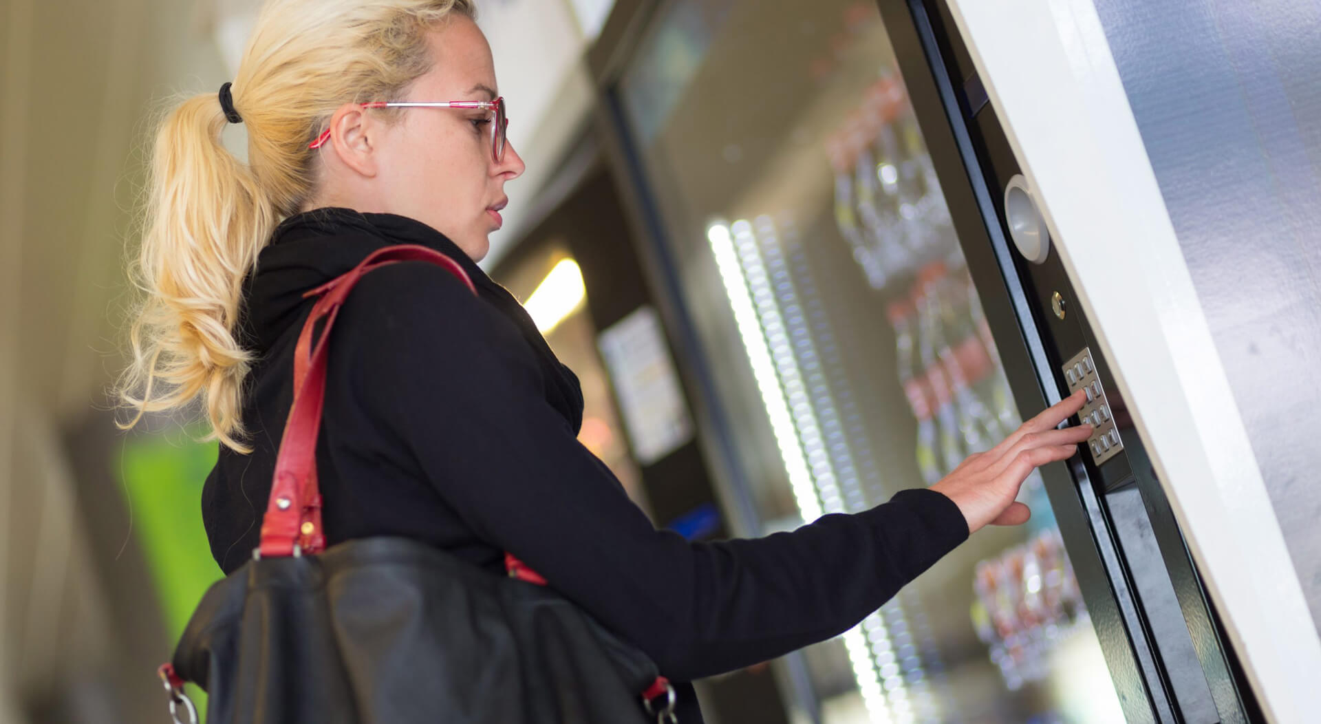 casual caucasian woman using a modern beverage vending machine