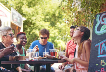 people having lunch beside a food truck in the city