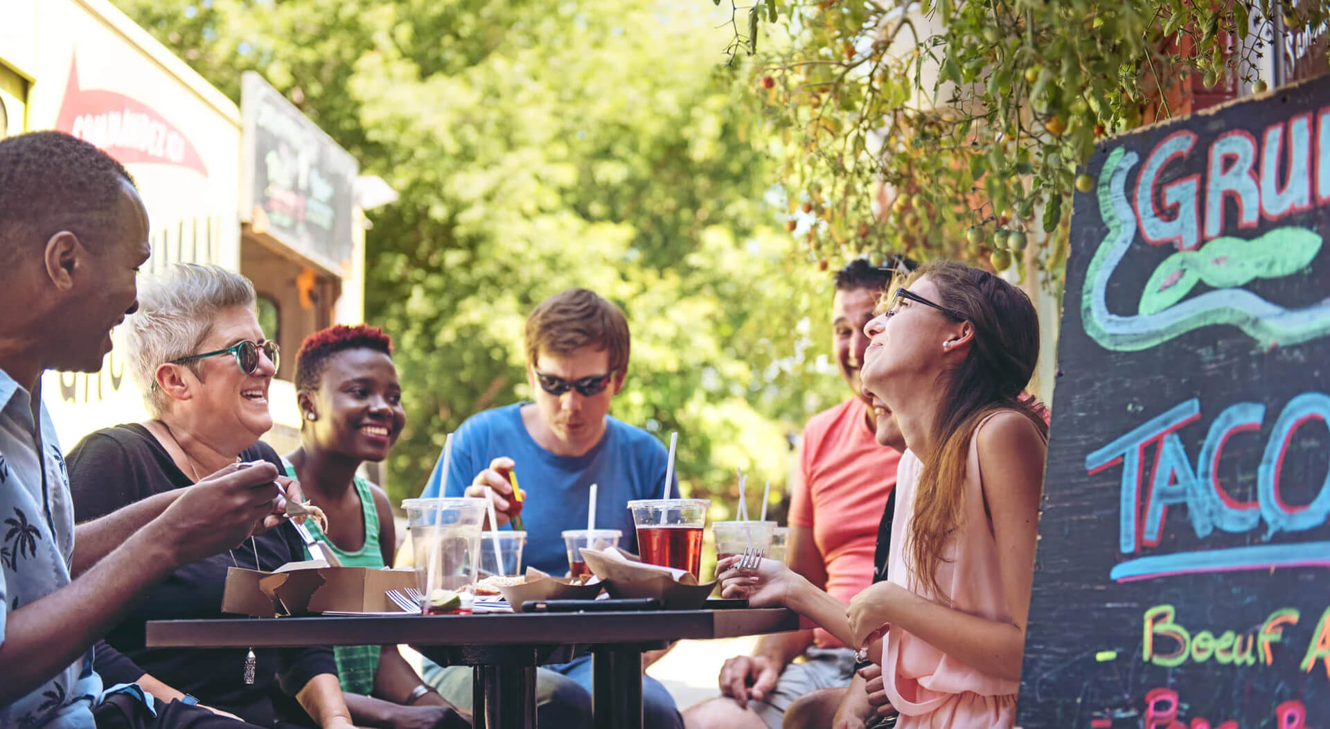 people having lunch beside a food truck in the city