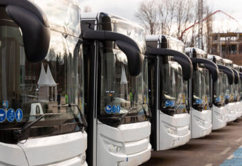 new white modern buses lined up at a bus parking lot