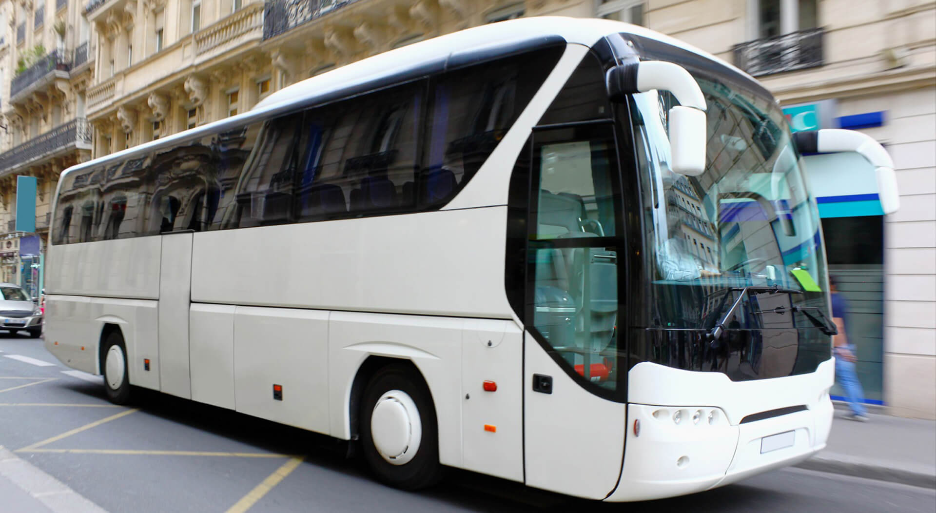 white shuttle bus driving in a street