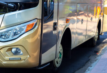 white and gold colored conversion bus on the side of the road