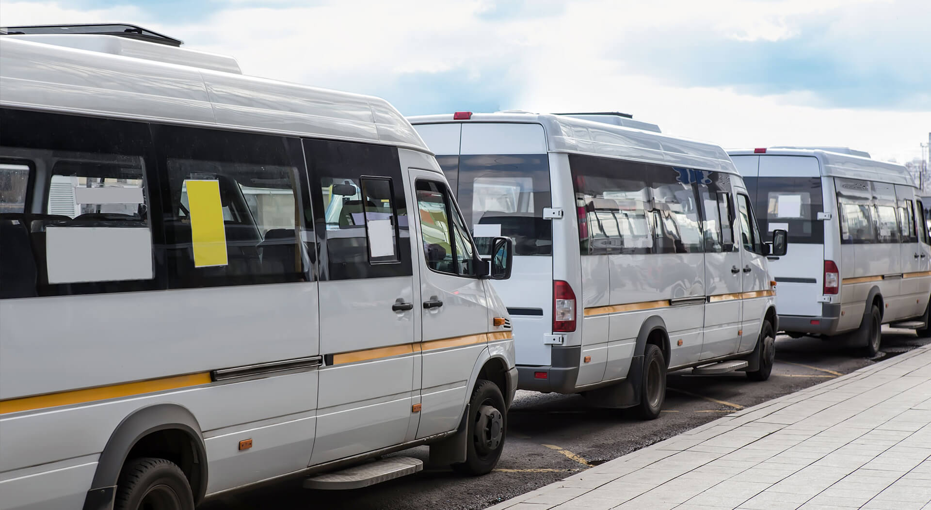 white shuttle buses at a bus stop