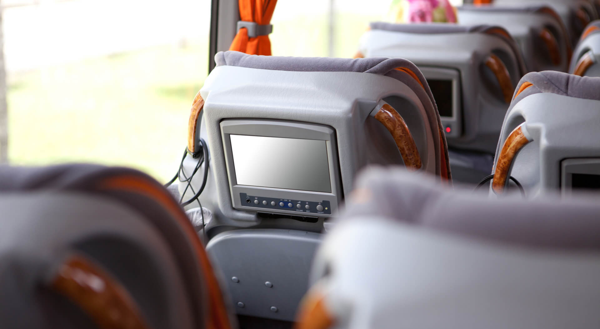 small television at the back of the headrest of a luxury bus' chair