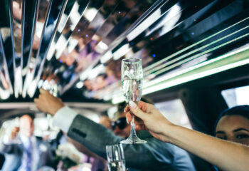 woman holding a champagne glass at a wedding party inside a limo