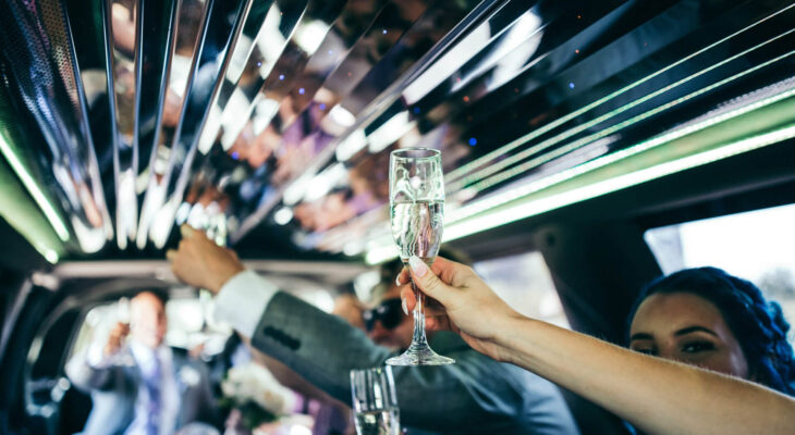 woman holding a champagne glass at a wedding party inside a limo