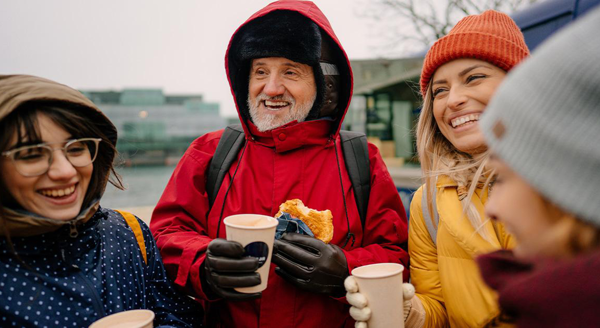 group of friends eating sandwiches and drinking iced tea from a food truck during winter