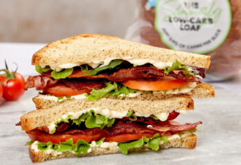 sandwich with lettuce, tomatoes, bacon on a ceramic plate