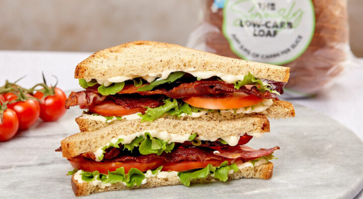 sandwich with lettuce, tomatoes, bacon on a ceramic plate