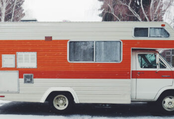 white and orange motorhome parked during winter