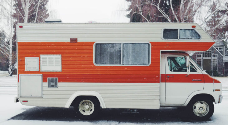 white and orange motorhome parked during winter