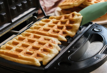 two waffles being prepared in a food truck for a customer