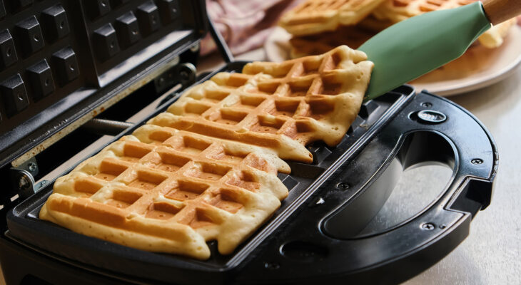 two waffles being prepared in a food truck for a customer