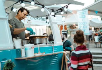 food truck operator serving a female customer at a festival