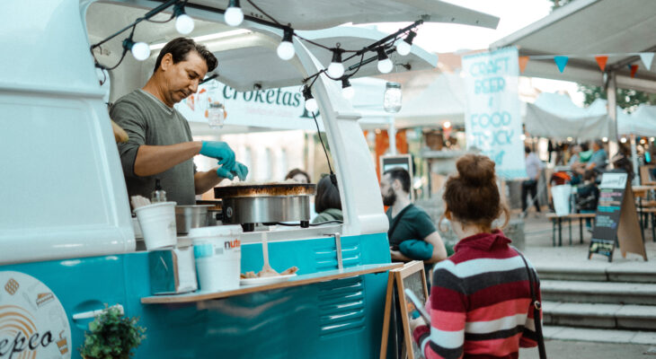 food truck operator serving a female customer at a festival