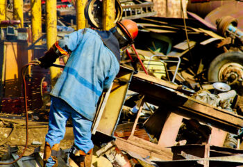 junk yard worker salvaging parts from a junk yard