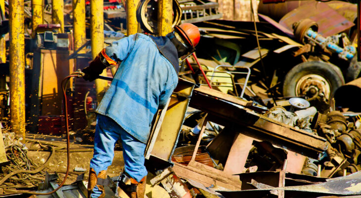 junk yard worker salvaging parts from a junk yard