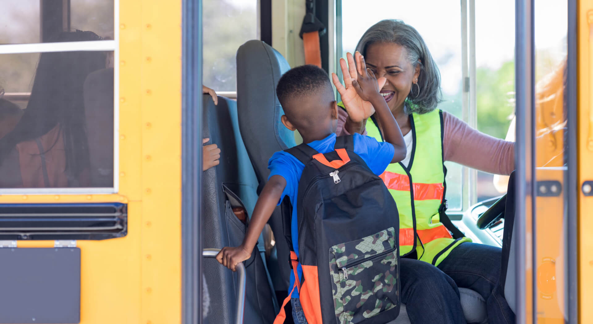 school bus driving picking up a kid